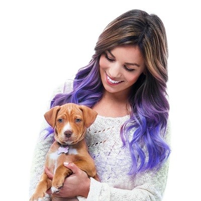 Lady showing her new coloured hair extensions while holding a puppy